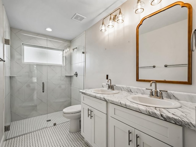 bathroom with vanity, a shower with shower door, and toilet