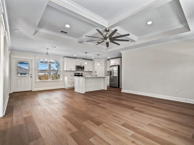 unfurnished living room featuring ceiling fan with notable chandelier, hardwood / wood-style flooring, coffered ceiling, crown molding, and beam ceiling