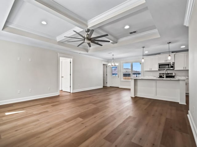 unfurnished living room featuring crown molding, ceiling fan with notable chandelier, and hardwood / wood-style flooring