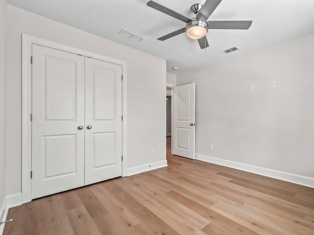 unfurnished bedroom featuring ceiling fan, light hardwood / wood-style floors, and a closet