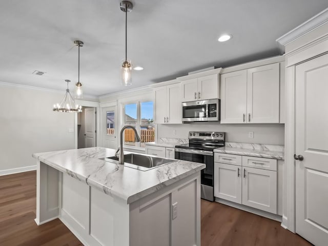 kitchen featuring pendant lighting, sink, white cabinetry, stainless steel appliances, and a center island with sink