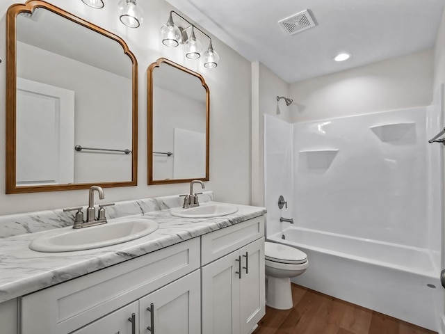 full bathroom with hardwood / wood-style flooring,  shower combination, toilet, and vanity