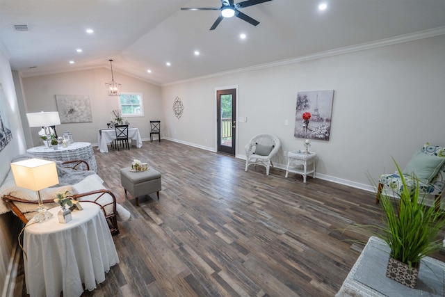 living room featuring lofted ceiling, ornamental molding, dark wood-type flooring, and ceiling fan with notable chandelier