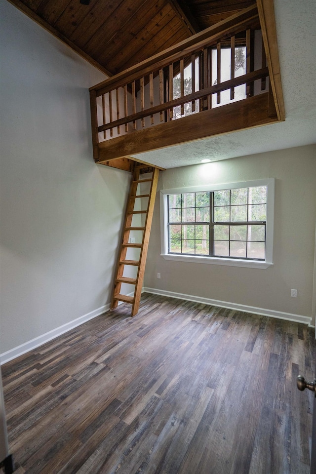 unfurnished living room featuring lofted ceiling, wooden ceiling, and dark wood-type flooring