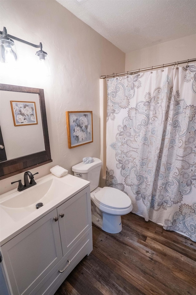 bathroom featuring hardwood / wood-style floors, vanity, a textured ceiling, and toilet