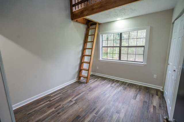 interior space featuring a textured ceiling, a closet, and dark wood-type flooring