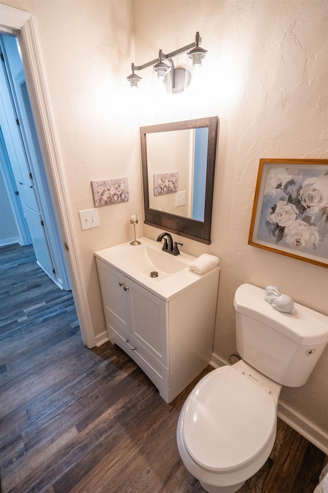 bathroom featuring vanity, toilet, and wood-type flooring