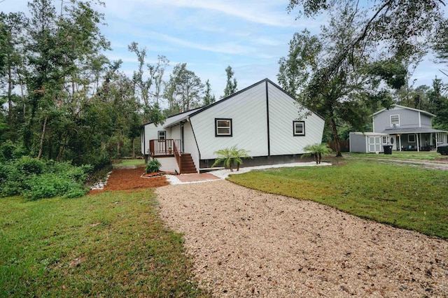 view of front of property with a front lawn and a storage unit