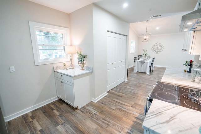 kitchen with pendant lighting, dark wood-type flooring, range, range hood, and white cabinetry