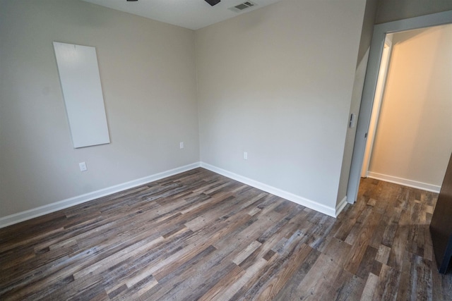 unfurnished room with ceiling fan and dark wood-type flooring