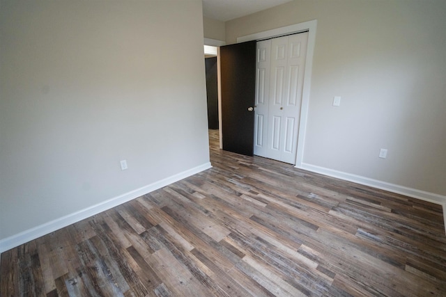 unfurnished bedroom featuring dark hardwood / wood-style floors and a closet