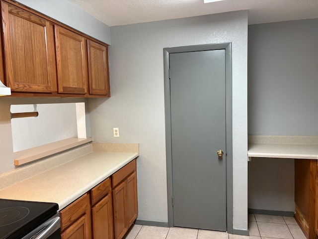 2020 Continental Ave Unit 120, Tallahassee, FL 32304 - kitchen with brown cabinetry, light countertops, and light tile patterned floors