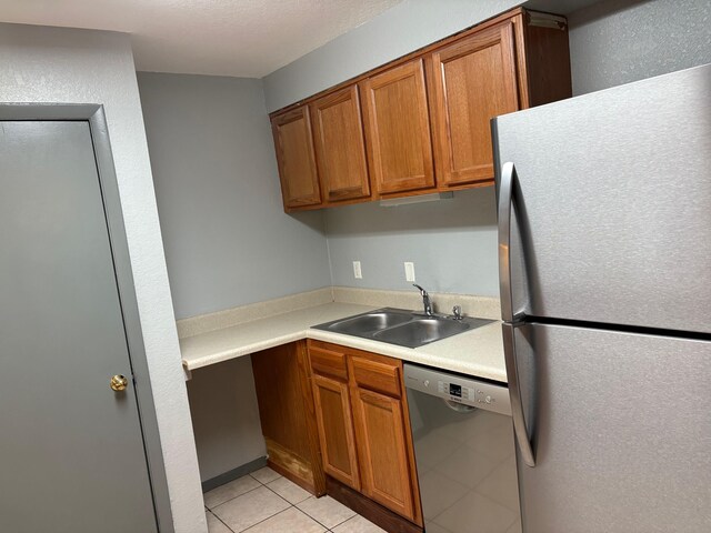 2020 Continental Ave Unit 120, Tallahassee, FL 32304 - kitchen with appliances with stainless steel finishes, brown cabinets, light tile patterned flooring, and light countertops