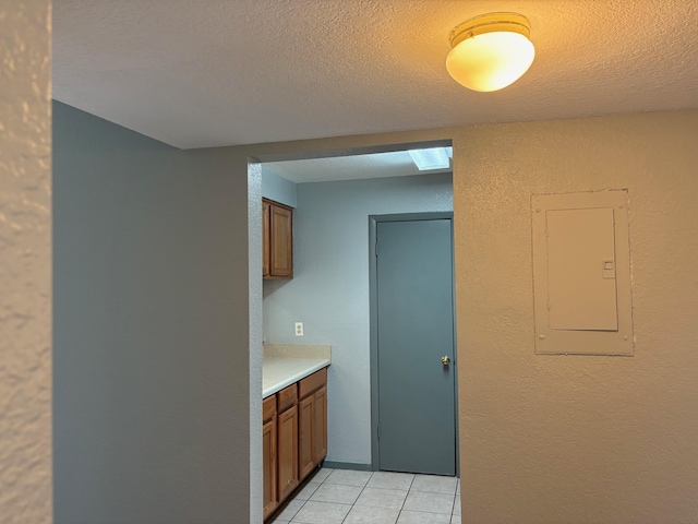 2020 Continental Ave Unit 120, Tallahassee, FL 32304 - kitchen with brown cabinets, electric panel, light countertops, light tile patterned floors, and a textured ceiling