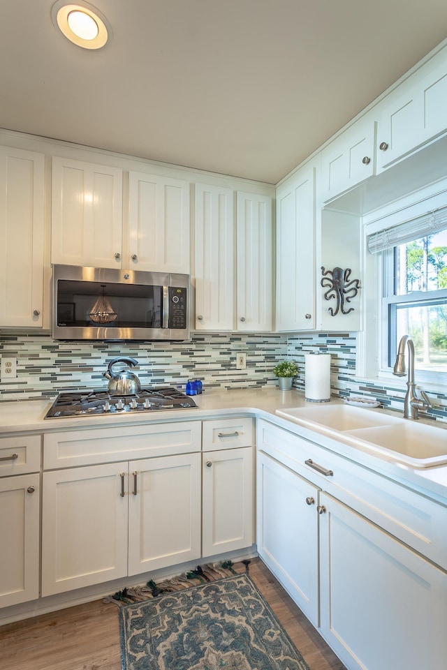 2433 Surf Rd, Panacea, FL 32346 - kitchen featuring appliances with stainless steel finishes, a sink, backsplash, white cabinetry, and light countertops