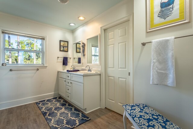 2433 Surf Rd, Panacea, FL 32346 - bathroom with wood finished floors, double vanity, crown molding, baseboards, and recessed lighting