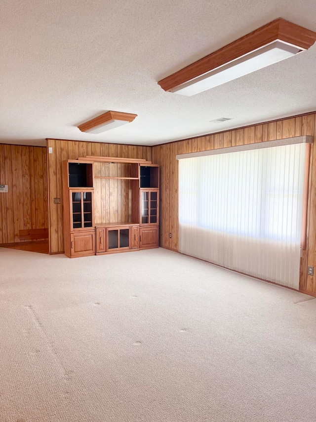 2048 W Gas Plant Rd, Perry, FL 32347 - unfurnished living room with wood walls, carpet flooring, and a textured ceiling
