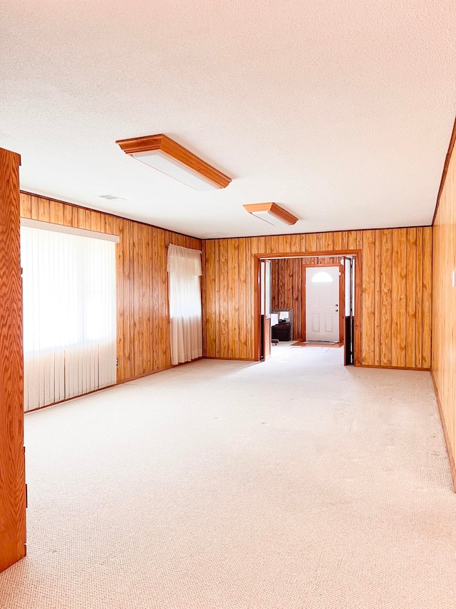 2048 W Gas Plant Rd, Perry, FL 32347 - spare room with light colored carpet, a textured ceiling, and wood walls