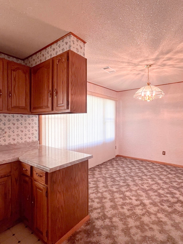 2048 W Gas Plant Rd, Perry, FL 32347 - kitchen featuring a textured ceiling, light countertops, brown cabinetry, a peninsula, and carpet floors