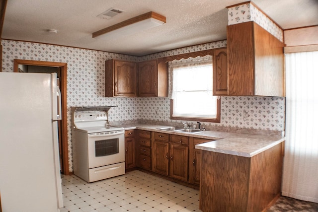 2048 W Gas Plant Rd, Perry, FL 32347 - kitchen with white appliances, wallpapered walls, light flooring, brown cabinetry, and light countertops