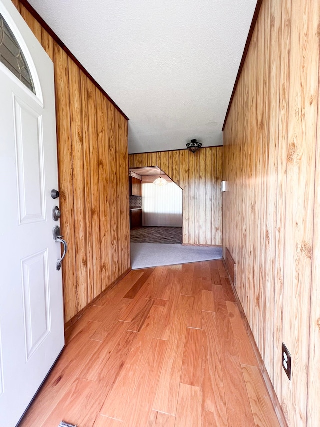 2048 W Gas Plant Rd, Perry, FL 32347 - foyer with light wood-type flooring, wooden walls, arched walkways, and a textured ceiling