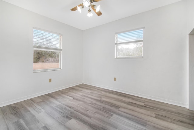 unfurnished room with ceiling fan, light wood-type flooring, and a wealth of natural light