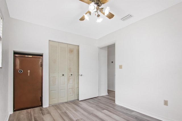 unfurnished bedroom featuring ceiling fan, light wood-type flooring, and a closet