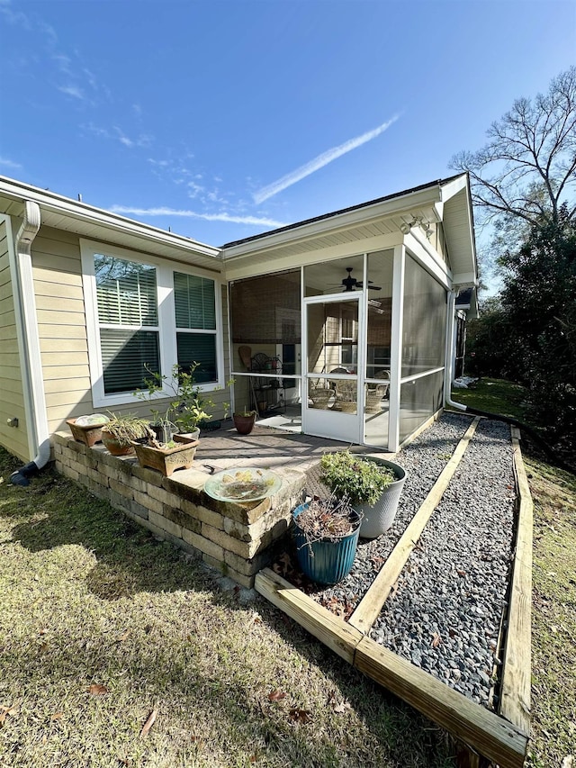 rear view of house featuring ceiling fan and a sunroom