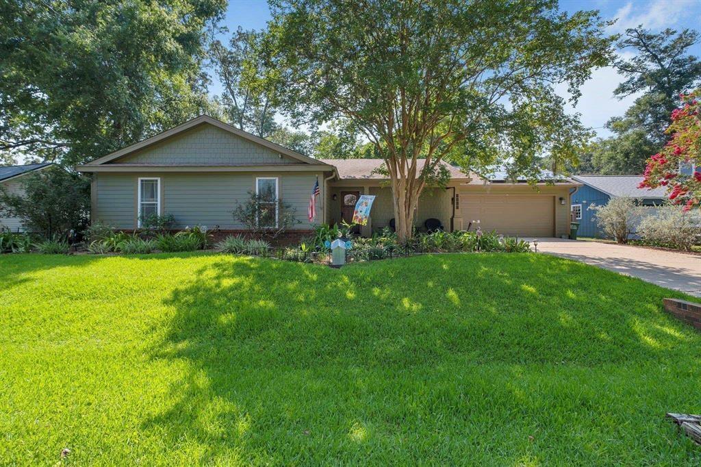 ranch-style home with a garage and a front lawn