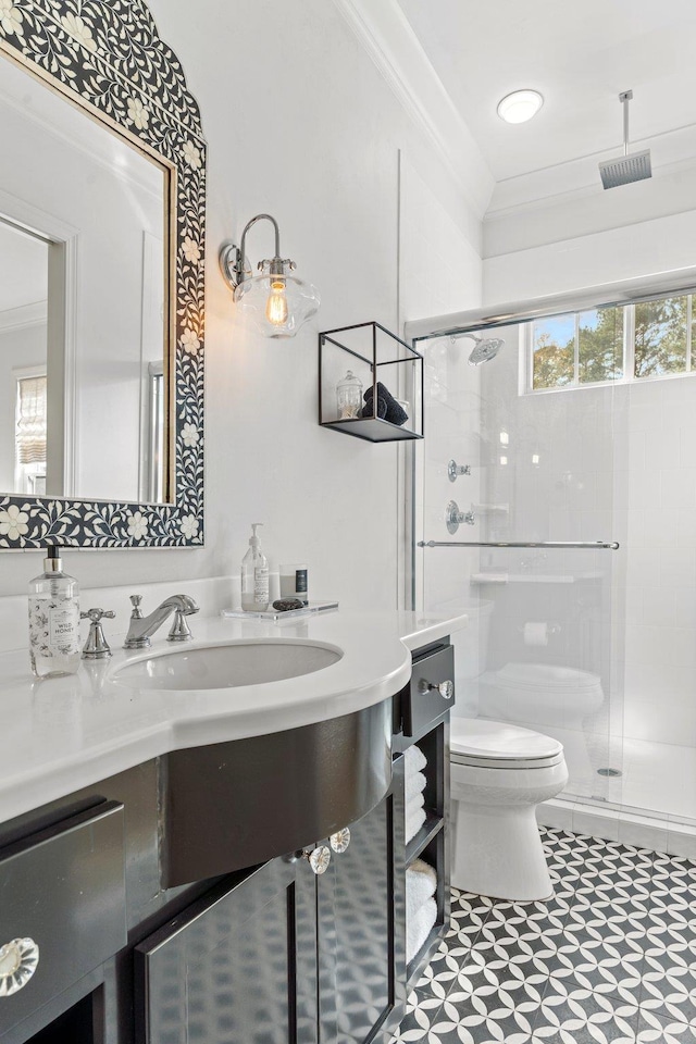 bathroom with crown molding, vanity, an enclosed shower, and toilet