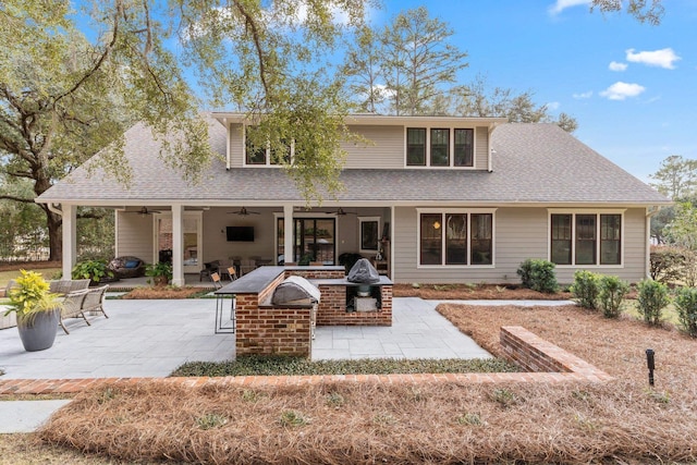 rear view of property featuring ceiling fan and a patio area