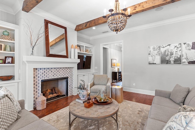 living room with built in shelves, an inviting chandelier, light wood-type flooring, beamed ceiling, and a tiled fireplace