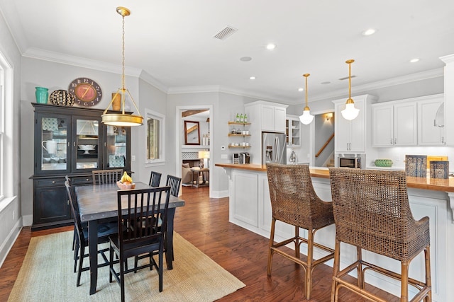 dining area featuring ornamental molding and dark hardwood / wood-style flooring