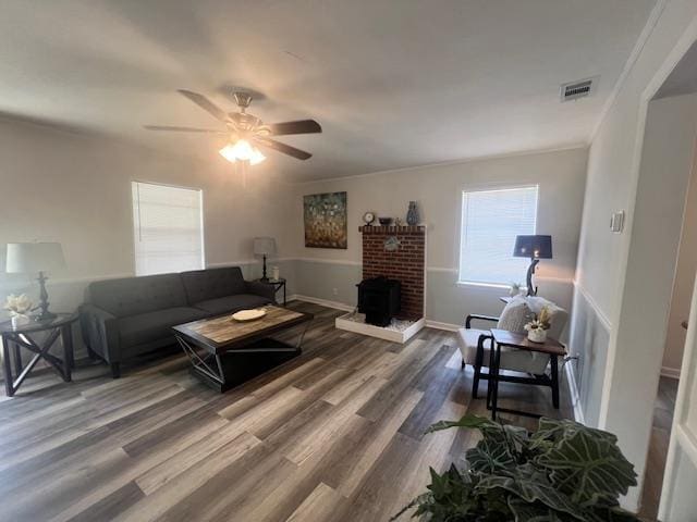 living area with ceiling fan, visible vents, baseboards, and wood finished floors