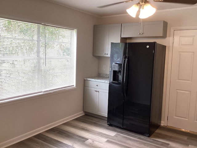 kitchen featuring crown molding, light wood-style floors, gray cabinets, and black fridge