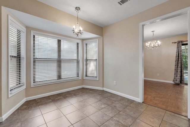 unfurnished dining area featuring light parquet floors and a notable chandelier