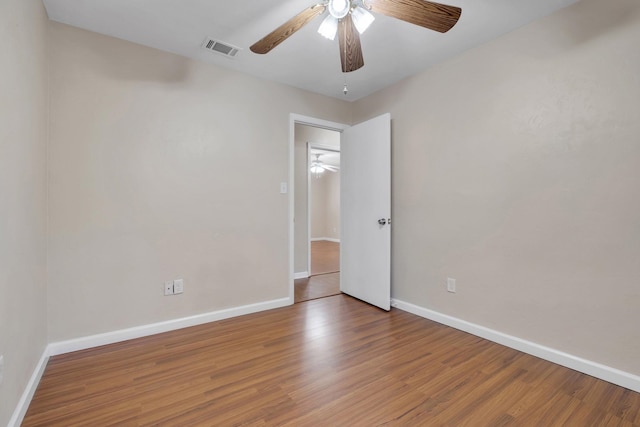 empty room with hardwood / wood-style floors and ceiling fan