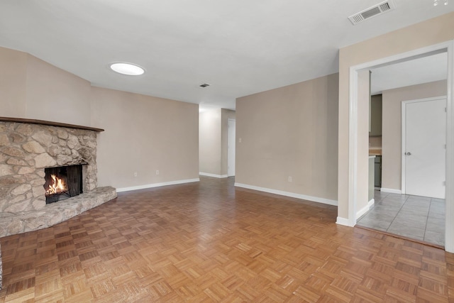 unfurnished living room with a fireplace and parquet flooring