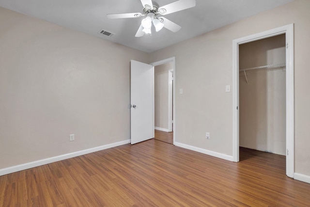 unfurnished bedroom with hardwood / wood-style flooring, ceiling fan, and a closet