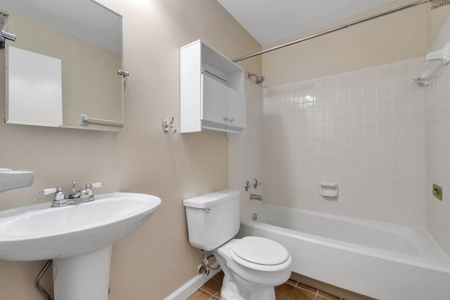 full bathroom with sink, tile patterned flooring, tiled shower / bath combo, and toilet