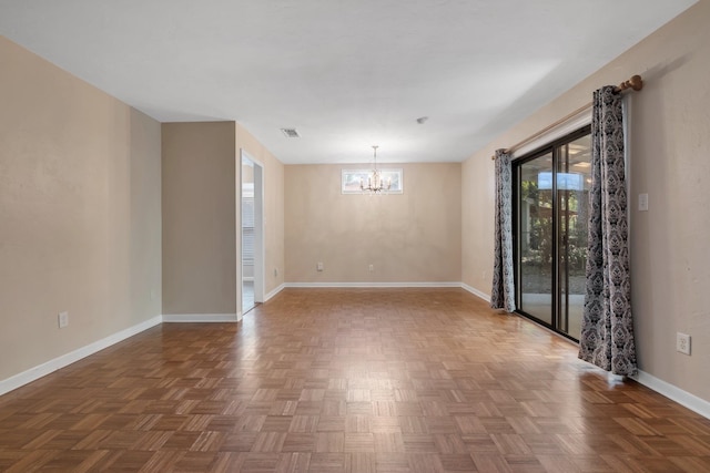 empty room featuring an inviting chandelier and parquet floors