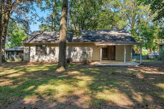 rear view of house featuring a yard and a patio area