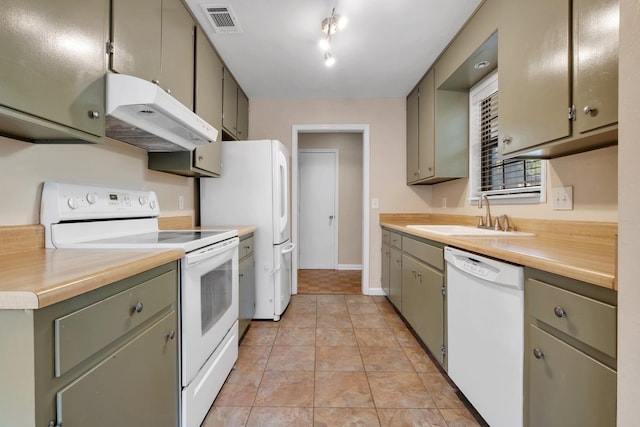 kitchen with light tile patterned floors, white appliances, and sink