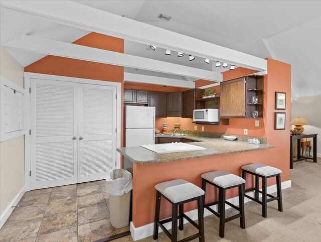 233 NE Maggie Cir, Steinhatchee, FL 32359 - kitchen with white appliances, open shelves, a peninsula, baseboards, and a breakfast bar