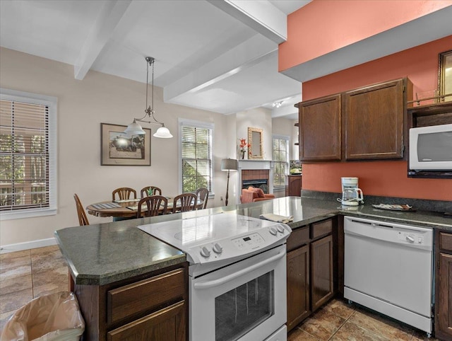 233 NE Maggie Cir, Steinhatchee, FL 32359 - kitchen featuring white appliances, dark countertops, a peninsula, beamed ceiling, and a fireplace