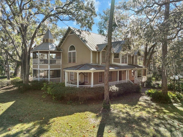 233 NE Maggie Cir, Steinhatchee, FL 32359 - back of house featuring metal roof, a lawn, covered porch, and a standing seam roof