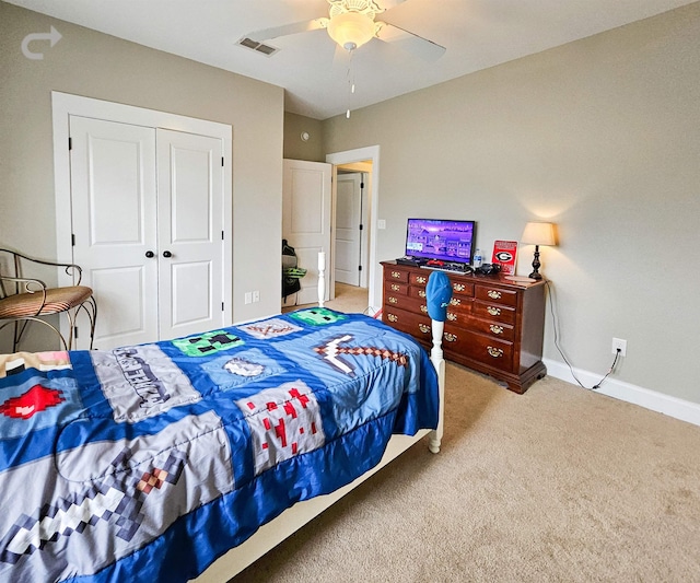 bedroom with ceiling fan, light colored carpet, and a closet