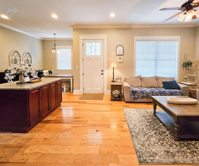 living room featuring crown molding, ceiling fan, and light hardwood / wood-style flooring