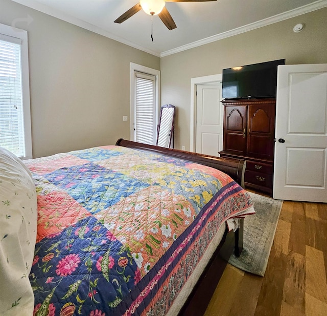 bedroom with ornamental molding, wood-type flooring, and ceiling fan