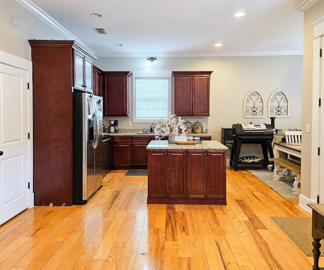 kitchen featuring crown molding, a center island, stainless steel fridge, and light hardwood / wood-style flooring